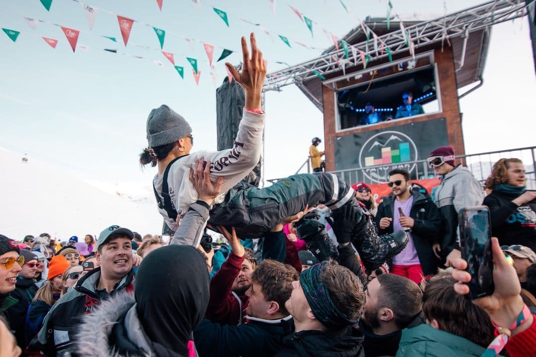 A woman crowdsurfs at a festival