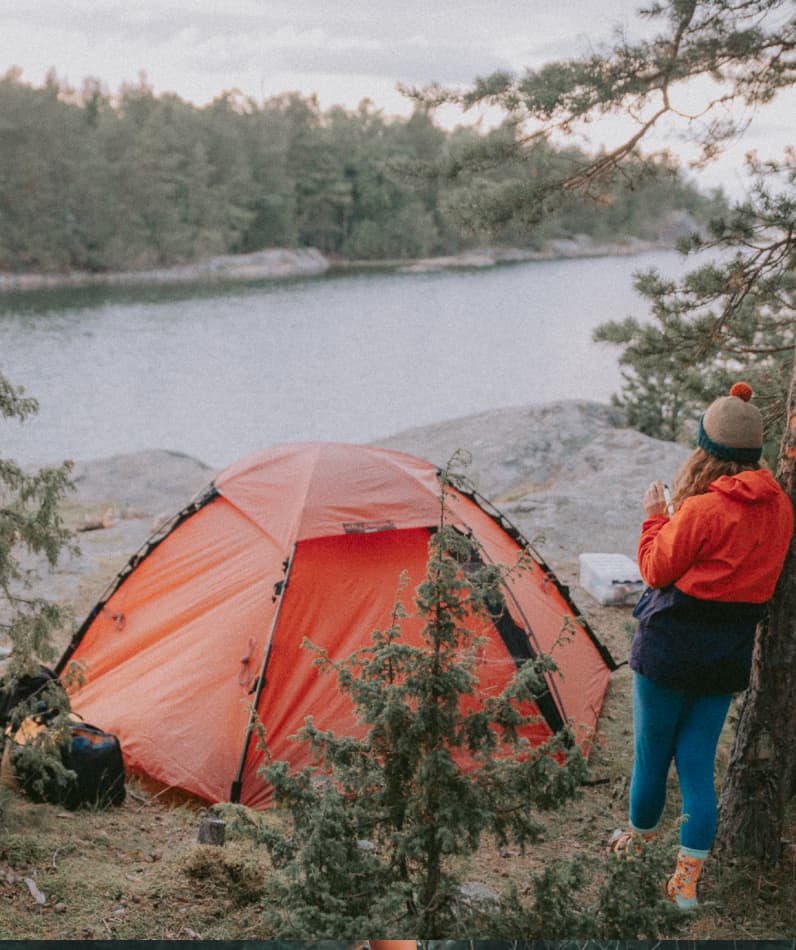 A woman camps by a river